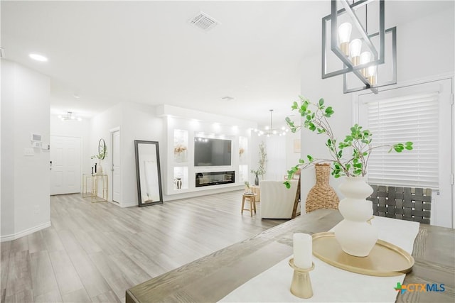 living room featuring a chandelier and light hardwood / wood-style flooring