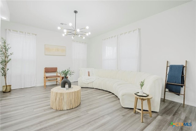 living room featuring light hardwood / wood-style floors and a chandelier