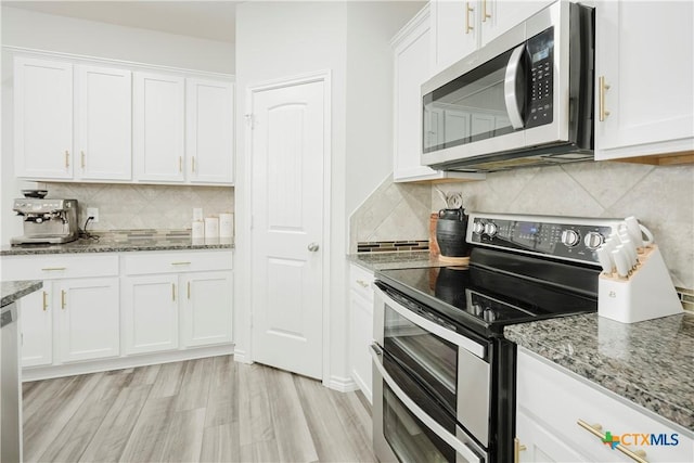 kitchen with light stone counters, stainless steel appliances, light wood-type flooring, and white cabinets