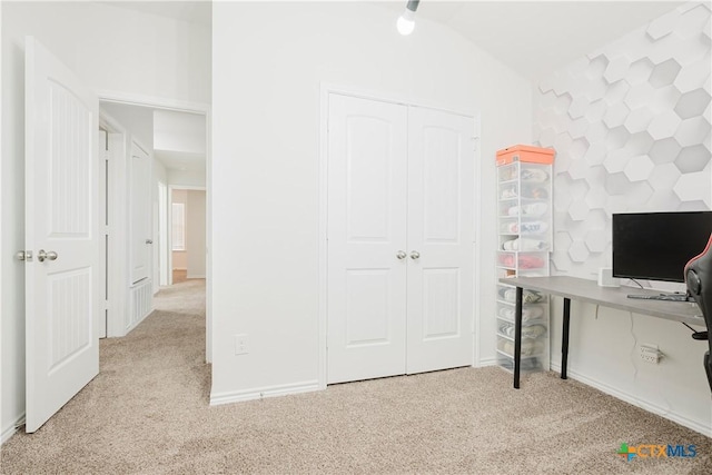 unfurnished office featuring lofted ceiling and light carpet