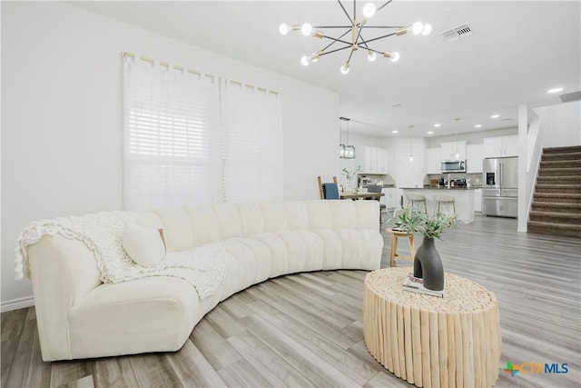 living room featuring light hardwood / wood-style flooring and a chandelier