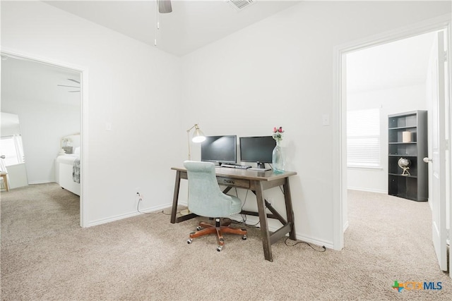 carpeted office space featuring ceiling fan