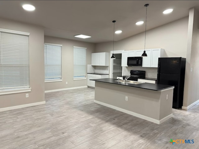 kitchen with pendant lighting, white cabinetry, a center island with sink, and black appliances