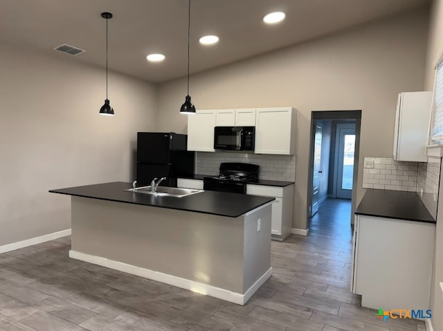 kitchen with sink, black appliances, pendant lighting, white cabinetry, and an island with sink