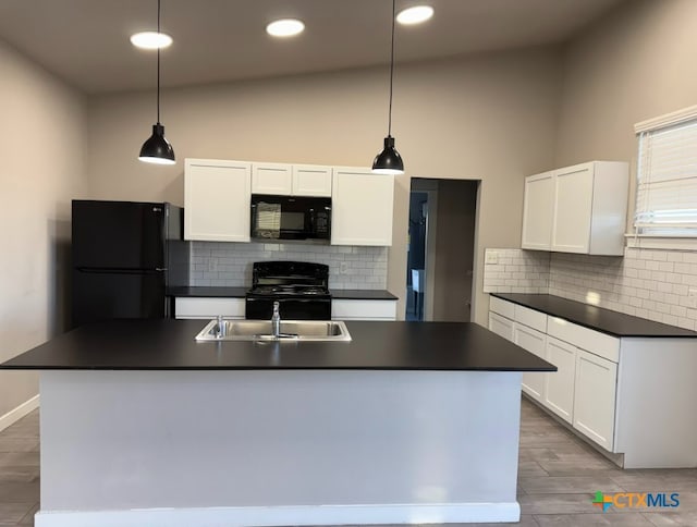 kitchen with black appliances, pendant lighting, white cabinets, and an island with sink