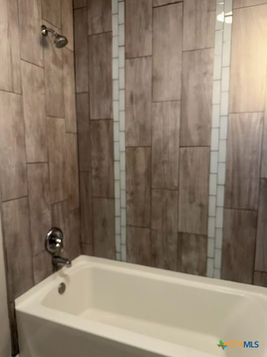 bathroom featuring tiled shower / bath