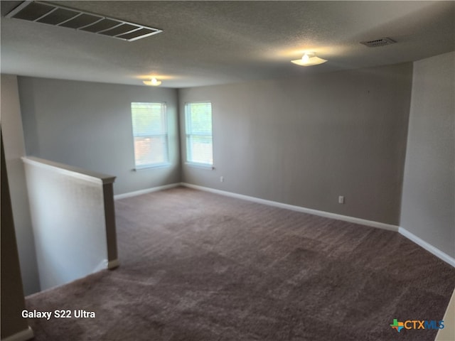 spare room with carpet flooring and a textured ceiling