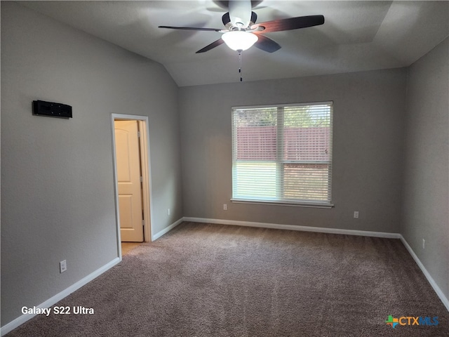 carpeted spare room with vaulted ceiling and ceiling fan