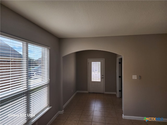 entryway featuring tile patterned flooring and a textured ceiling