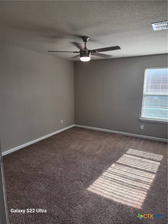 carpeted empty room featuring ceiling fan and a textured ceiling