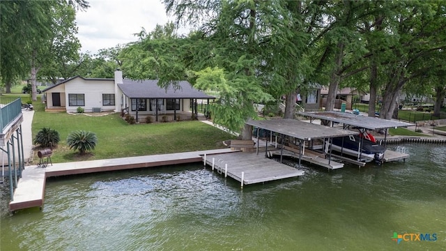 view of dock with a lawn and a water view