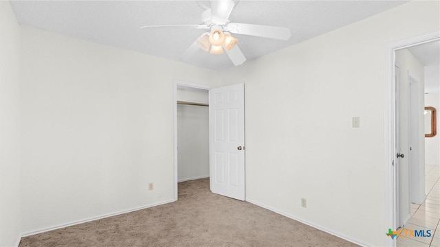 unfurnished bedroom featuring a ceiling fan, baseboards, light carpet, and a closet