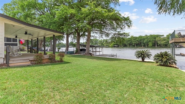 view of yard with a ceiling fan and a water view