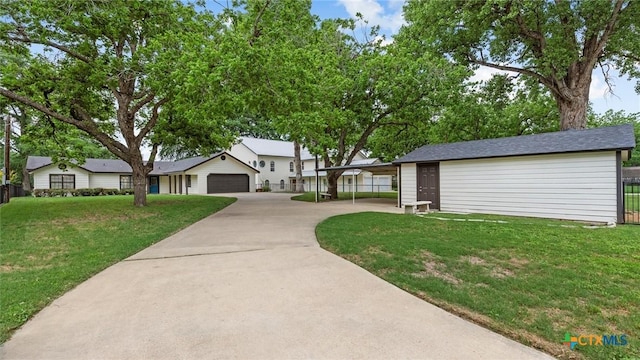 exterior space with a lawn, fence, and driveway