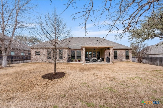 back of house featuring brick siding, a yard, a patio, a ceiling fan, and a fenced backyard