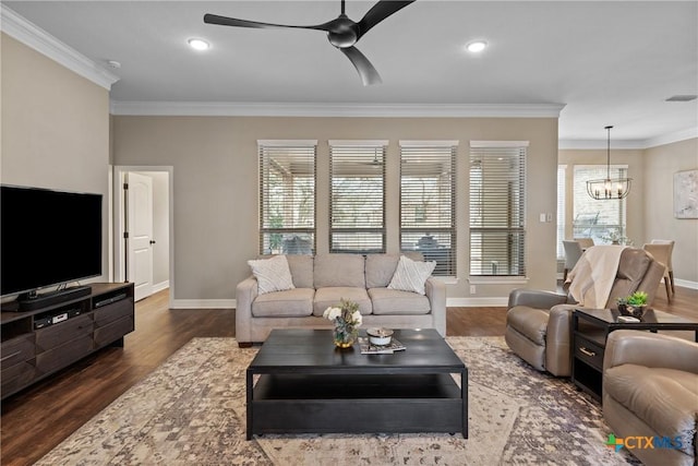 living area with ornamental molding, wood finished floors, and ceiling fan with notable chandelier