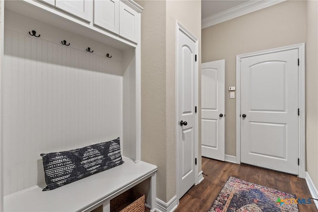 mudroom with dark wood-style flooring, crown molding, and baseboards