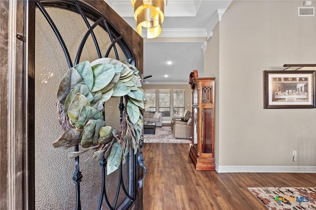 entryway with visible vents, crown molding, baseboards, and wood finished floors