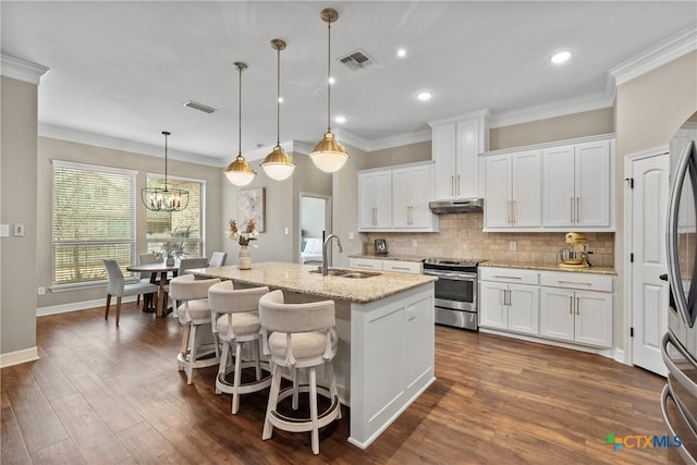 kitchen featuring visible vents, a sink, stainless steel appliances, under cabinet range hood, and backsplash