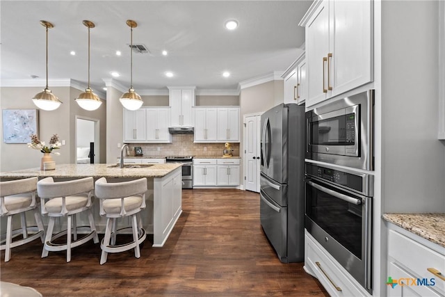 kitchen featuring visible vents, stainless steel appliances, under cabinet range hood, white cabinetry, and backsplash