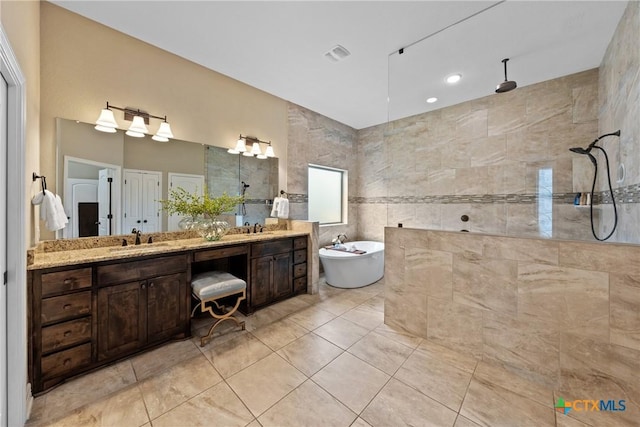 full bath with tile walls, double vanity, a freestanding bath, a sink, and walk in shower