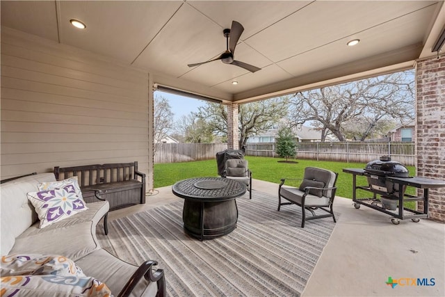 wooden terrace with grilling area, an outdoor hangout area, a yard, a fenced backyard, and a ceiling fan