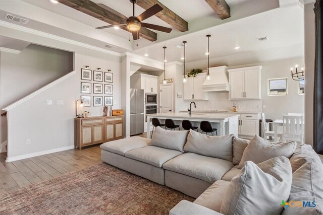 5410 Tabbs Ct, Belton, TX 76513 - living room with ceiling fan, a chandelier, light wood-style floors, beam ceiling, and baseboards