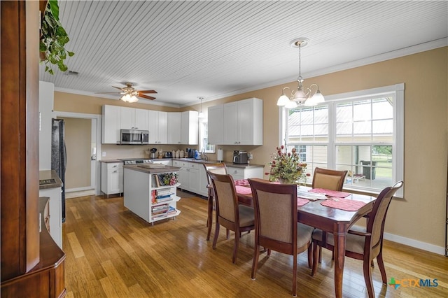 124 County Road 356b, Shiner, TX 77984 - dining area with light wood-style floors, ornamental molding, a chandelier, a ceiling fan, and baseboards