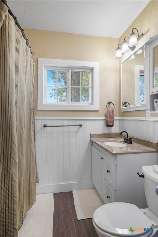 124 County Road 356b, Shiner, TX 77984 - bathroom with toilet, vanity, wainscoting, wood finished floors, and a shower with shower curtain