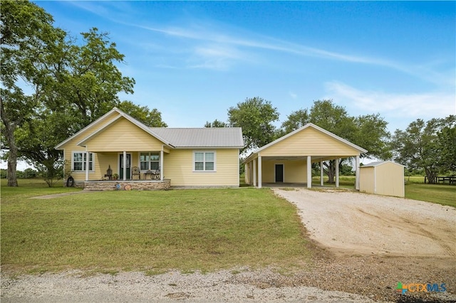 124 County Road 356b, Shiner, TX 77984 - view of front of home featuring dirt driveway, a porch, a front lawn, metal roof, and an outbuilding