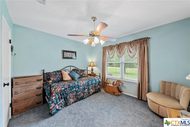 carpeted bedroom featuring a ceiling fan and a textured ceiling