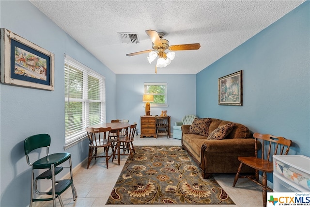 tiled living room featuring a textured ceiling and ceiling fan