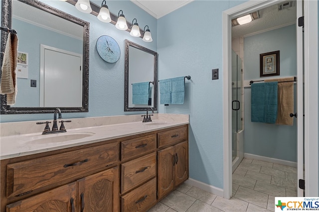 bathroom with a shower with door, ornamental molding, vanity, a textured ceiling, and tile patterned flooring