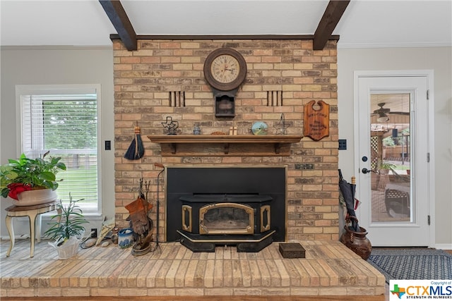 room details featuring ornamental molding, beamed ceiling, and a wood stove