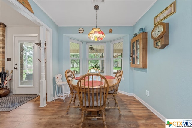 dining area featuring hardwood / wood-style floors, ornamental molding, and plenty of natural light