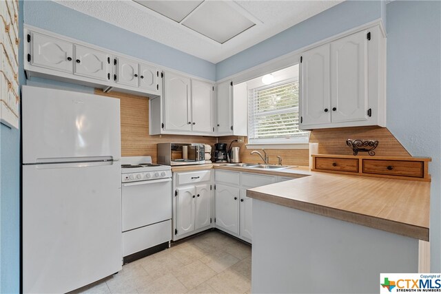 kitchen featuring white cabinets, sink, and white appliances