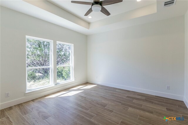 unfurnished room featuring ceiling fan and a raised ceiling