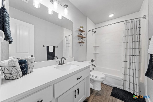 full bath with toilet, shower / tub combo, wood finished floors, and vanity