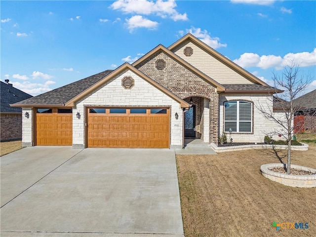 view of front of house with driveway, roof with shingles, an attached garage, a front lawn, and brick siding