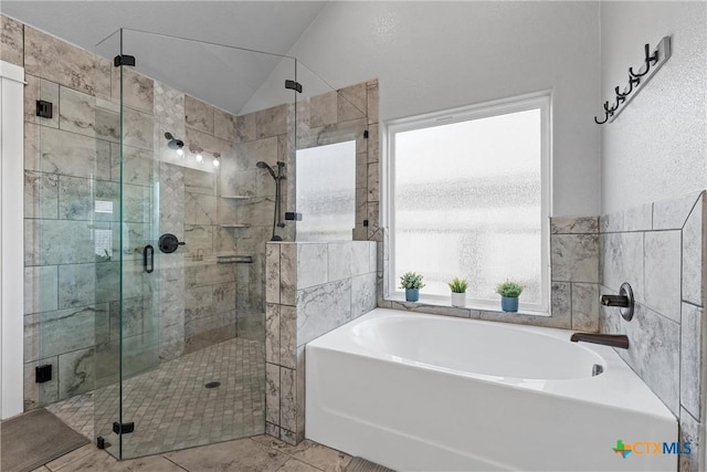 full bathroom featuring vaulted ceiling, a garden tub, tile walls, and a shower stall