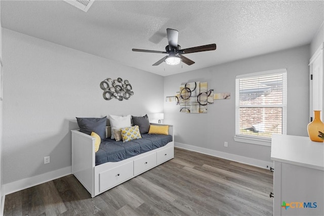 bedroom featuring visible vents, a textured ceiling, and wood finished floors