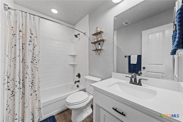 full bathroom with toilet, wood finished floors, vanity, visible vents, and shower / tub combo with curtain