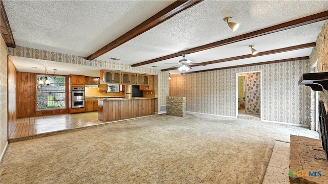 162 Lone Oak St, Seguin, TX 78155 - unfurnished living room featuring a textured ceiling, light carpet, wallpapered walls, beam ceiling, and a ceiling fan