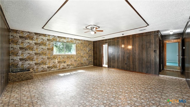 162 Lone Oak St, Seguin, TX 78155 - spare room featuring wood walls, a ceiling fan, and a textured ceiling