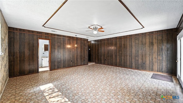 162 Lone Oak St, Seguin, TX 78155 - unfurnished room featuring wood walls, a ceiling fan, and a textured ceiling