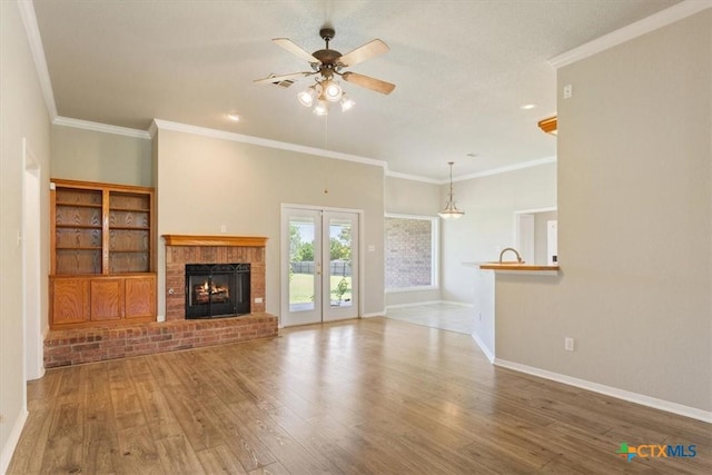 6809 Oak Vw, Belton, TX 76513 - unfurnished living room with ceiling fan, wood finished floors, a brick fireplace, and crown molding