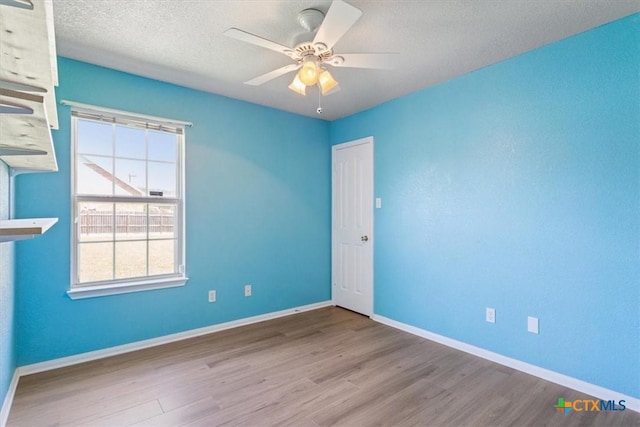 6809 Oak Vw, Belton, TX 76513 - empty room with wood finished floors, plenty of natural light, ceiling fan, and a textured ceiling