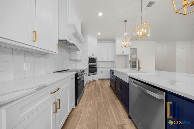 5273 Comanche Dr, Temple, TX 76502 - kitchen with appliances with stainless steel finishes, a chandelier, white cabinets, light stone counters, and pendant lighting