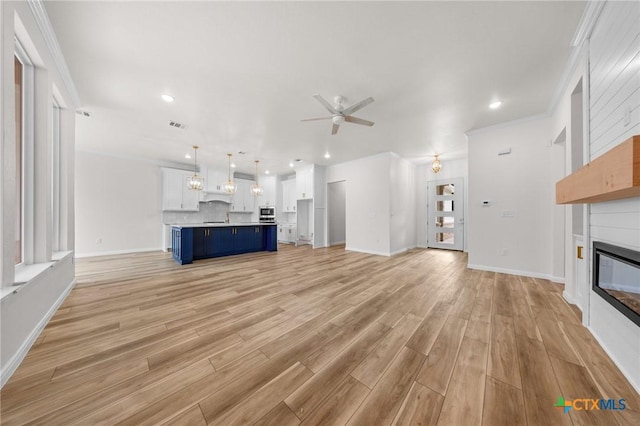 5273 Comanche Dr, Temple, TX 76502 - unfurnished living room with ceiling fan, a fireplace, light wood-type flooring, crown molding, and recessed lighting