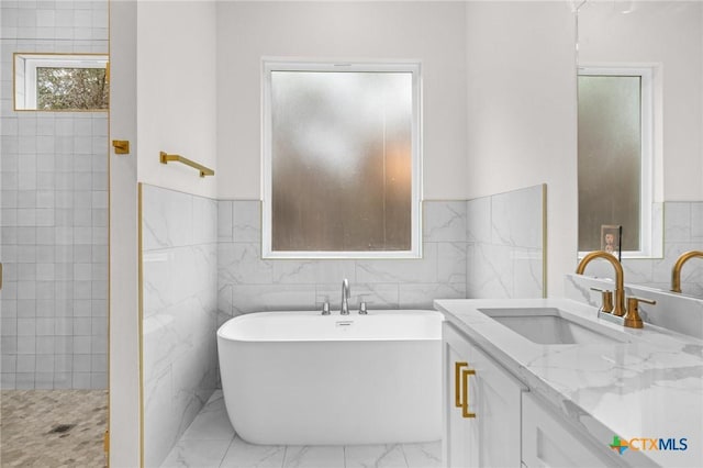 5273 Comanche Dr, Temple, TX 76502 - full bath with marble finish floors, a freestanding tub, vanity, tile walls, and a wainscoted wall